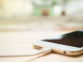 Smartphone charging battery on wooden table