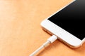 Smartphone charging with power bank on wood board. Royalty Free Stock Photo