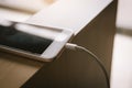 Smartphone charging with power bank on wood table Royalty Free Stock Photo