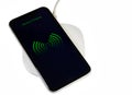 Smartphone Charging On A Wireless Base With White Background