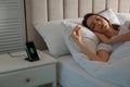 Smartphone charging on wireless pad and woman sleeping