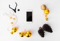 Smartphone christmas composition. cones and christmas decorations on white background. flat lay top view.