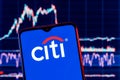 Smartphone with Citigroup logo. Citigroup stock chart on the background