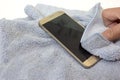 Smartphone cleaning dirty screen with blue microfiber fabric