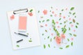 Smartphone and clipboard mock up with floral decoration flat lay