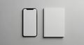 Smartphone and a closed book placed side by side on a smooth, gray surface. The Royalty Free Stock Photo