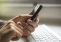 Smartphone and computer keyboard at hand. Manager.