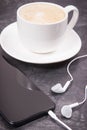 Smartphone with connected headphones and coffee with milk. Relaxation time with music Royalty Free Stock Photo