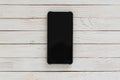 Smartphone with dark screen on center of white wood texture background Royalty Free Stock Photo