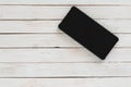 Smartphone with dark screen on white wood texture background Royalty Free Stock Photo