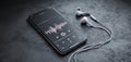 The smartphone displaying an audio waveform with earphones nearby on a textured surface. AI generated image Royalty Free Stock Photo