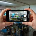 Smartphone displaying augmented reality data overlay on industrial machinery Royalty Free Stock Photo