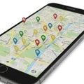 Smartphone displaying a digital map interface with multiple colored location pins, Royalty Free Stock Photo