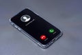 Smartphone displaying an incoming call screen with Decline and Accept buttons, placed on a sleek gray desk