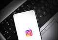 Smartphone displaying Instagram logo on laptop keyboard for social media interaction illustrative Royalty Free Stock Photo