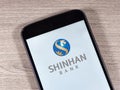 Smartphone displaying logo of Shinhan Bank, a bank headquartered in Seoul, South Korea Royalty Free Stock Photo