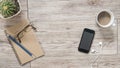 Smartphone, earphones, notebook and coffee on wooden background Royalty Free Stock Photo