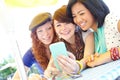 Smartphone entertainment. A group of adolescent girls laughing as they look at something on a smartphone screen.