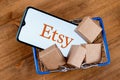 Smartphone with Etsy logo on the screen and parcels in shopping cart Royalty Free Stock Photo