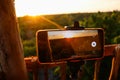 Smartphone filming a forest under the sunlight during the sunset in the evening