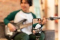 Smartphone Filming Japanese Musical Blogger Guy Playing Electric Guitar Indoors