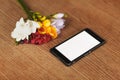 Smartphone and flowers on the table