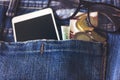 Smartphone in front jeans pocket with eye glasses and Algeria coin money.