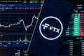 A smartphone with the FTX logo on the background of the live trading webpage