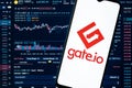 A smartphone with the Gate.io logo on the background of the live trading webpage