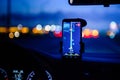 Smartphone with map on the screen in car. Automobile dashboard in night mode Royalty Free Stock Photo