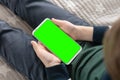 Smartphone with a green screen in hand child . close up top view Phone a for keying is holding kid Royalty Free Stock Photo