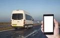 Smartphone in hand on the background of a minibus in which people are transported. Smartphone application concept for passenger