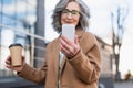 Smartphone in hand of blurred businesswoman