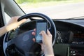 Smartphone in a hand of car driver. Navigation map on touch screen of device