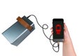 The smartphone in the hand is charged from a large power bank (charging station) via a USB cable Royalty Free Stock Photo