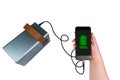 The smartphone in the hand is charged from a large power bank (charging station) via a USB cable on a transparent background Royalty Free Stock Photo