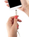 Smartphone in the hand of a woman. Connect the USB cable charger