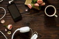 Smartphone, headphones, coffee cup on a wooden table. Top view flat lay background.