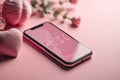 Smartphone with a heart on a pink screen, roses, vases and a candle on a pink surface. Valentine's Day concept for