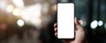 The smartphone held in hand showcasing a blank screen against a bokeh background. AI generated image Royalty Free Stock Photo