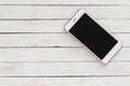 Smartphone iphone with dark screen on white wood texture background Royalty Free Stock Photo