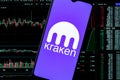 A smartphone with the Kraken logo on the background of the live trading webpage. Kraken dashboard