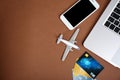 Smartphone, laptop, credit cards and toy plane on color background, flat lay with space for text. Royalty Free Stock Photo