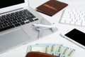 Smartphone with laptop, money and toy plane on light background. Royalty Free Stock Photo