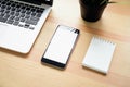 Smartphone and laptop on table in office room, for graphics display montage.