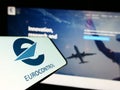 Smartphone with logo of air traffic management organization Eurocontrol on screen in front of website.