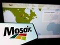 Smartphone with logo of American fertilizer producer The Mosaic Company on screen in front of website.