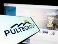 Smartphone with logo of American home construction company PulteGroup Inc. on screen in front of website.