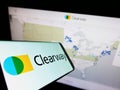 Smartphone with logo of American renewables company Clearway Energy Inc. on screen in front of website.