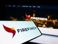 Smartphone with logo of Australian gold mining company Firefinch Limited on screen in front of business website.